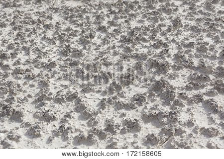White arid cracked lumpy dry textured desert soil from side