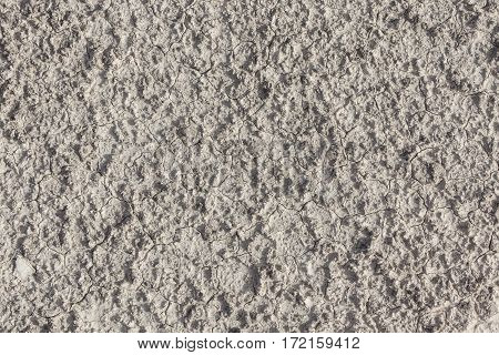 White arid cracked lumpy dry textured desert soil from above