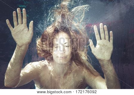 Woman under water. A young woman is trapped in a water surface. Hands resting on. summer feeling.