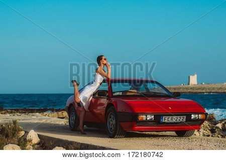 Young Beautiful Girl In Sunglasses Posing Near The Red Ferrari