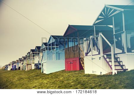 Row of colored beach huts with stormy blue sky on the beach of Tankerton near Whitstable in Kent, UK