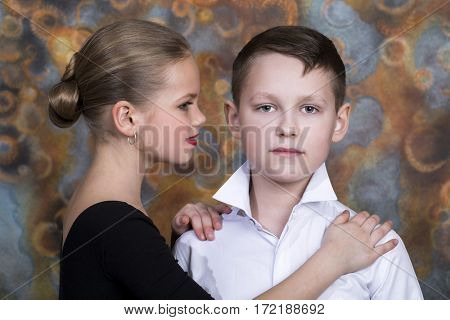 Young boy and girl are dancing on the studio wall background