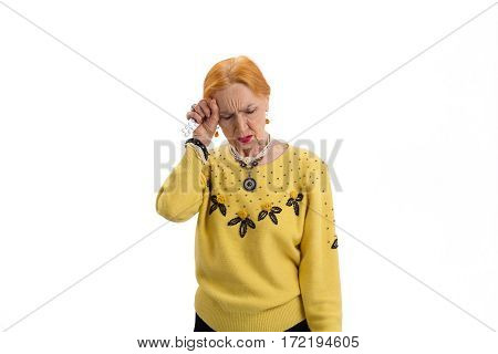 Elderly woman with pills isolated. Lady has headache. Time to take aspirin.