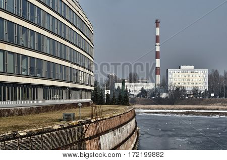 The facade of a modern building in the old river port and chimney power plant in Poznan