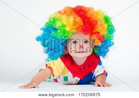 Children clown with a red nose multicolored wig in with balls. On a white background.