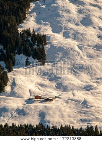Evening view of alpine hut in the steep slope. Winter backountry ski touring area, Austrian Alps, Europe.