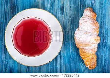 Croissant with kissel on blue background. Studio Photo