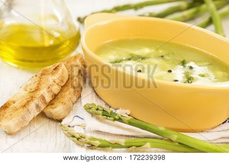 Asparagus soup with a toast bread and olive oil