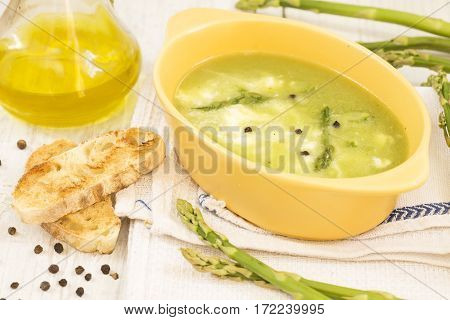 Asparagus soup with a toast bread and olive oil