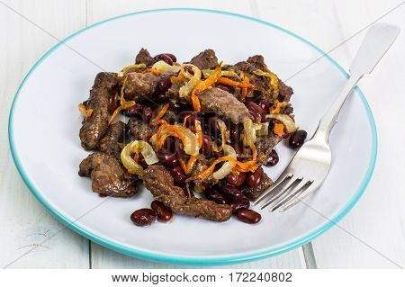 Beef liver, onions, carrots fried on palte. Studio Photo