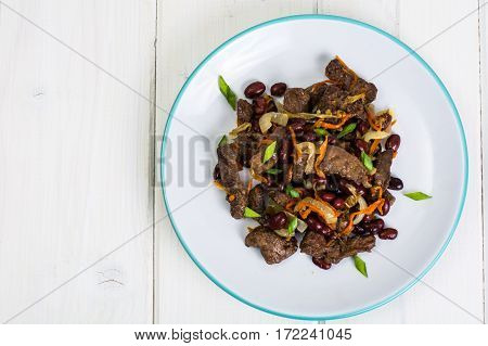 Beef liver, onions, carrots fried on palte. Studio Photo