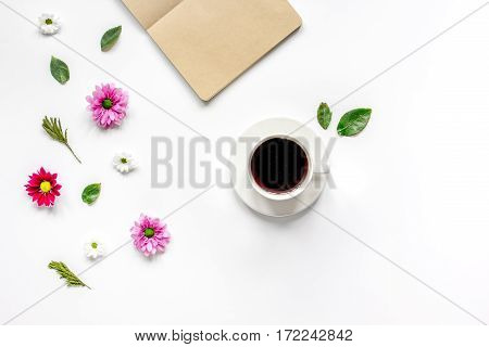 Froral flat lay with cup of coffee and craft notepaper on white background top view mockup
