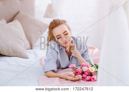 attractive female resting on the bed in the light bedroom