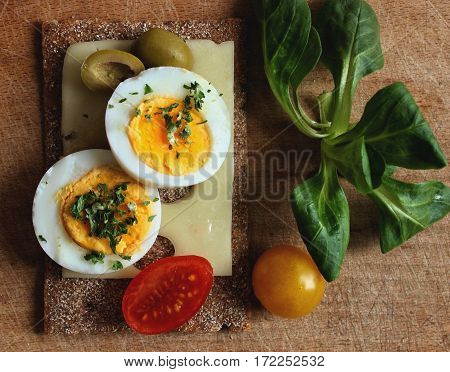 Egg sandwich with cheese, olives, tomatoes an lamb's lettuce