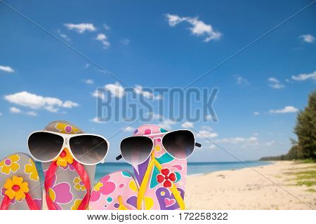 beach shoes with sunglasses on tropical sea and sky background