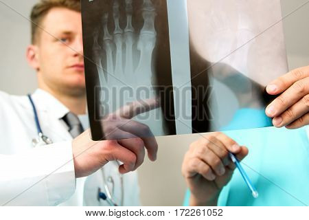 healthcare medical and radiology concept - Male doctors looking at x-ray of foot