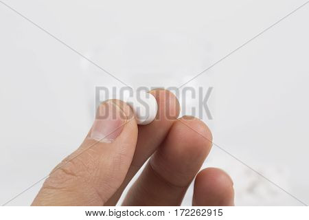 Round white pills and glass of water on a table waiting for eat