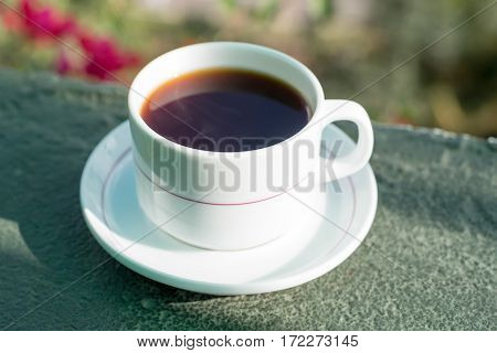 Morning cup of tea drinking on balcony on flower background