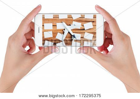 Woman hand using smart phone searching Preparation traveling and to do list with paper noted and airplane on vintage wooden background. Travel concepts Isolated on white background.