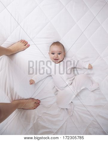 Happy Addorable Baby Boy And The Legs Of His Mother.