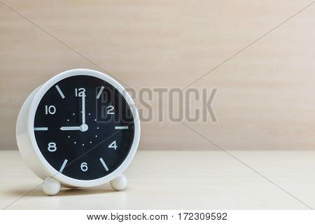 Closeup alarm clock for decorate in 9 o'clock on brown wood desk and wall textured background with copy space