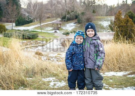 Two Little Kids Boys, Friends Holding Hands And Hugging. Adorable Siblings In Bright Colorful Clothe
