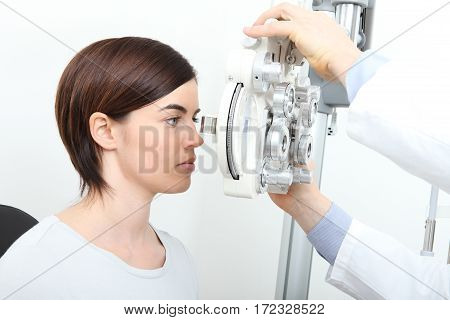 woman doing eyesight measurement with optical phoropter