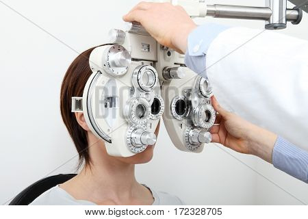 woman doing eyesight measurement with optical phoropter