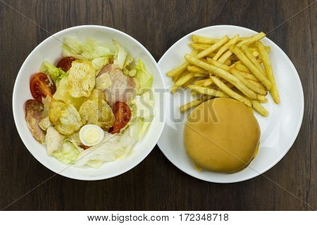 Caesar salad cheeseburger fries delicious healthy food tomatoes croutons Parmesan cheese and fresh mozzarella junk food fast food cheese meat bad food not healthy