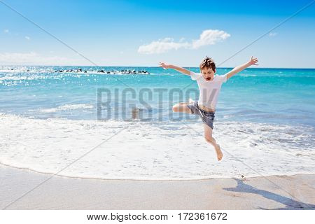 Happy 7 Years Boy Jumping On The Beach