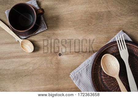 Rustic Kitchen Utensils: the Ceramic Plates and Wooden Cutlery on Wooden Background. Home Wares. Kitchen Decor in Rustic Style. View From Above With Copy Space.