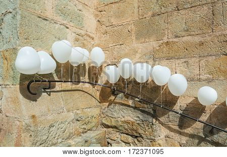 For a wedding is the entrance of a church in Largentiere in the Ardeche region of France decorated with white heart-shaped balloons
