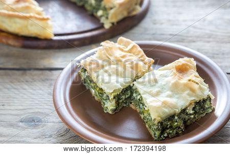 Spanakopita - Greek spinach pie on the wooden background