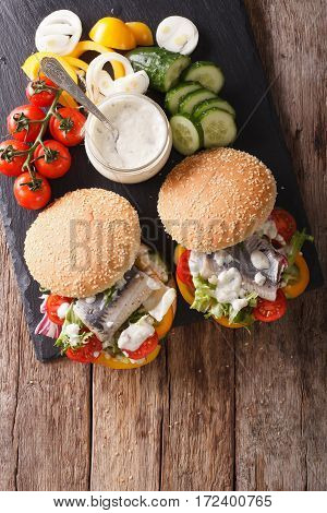 Fishburger With Herring, Gravy And Fresh Vegetables Close-up. Vertical Top View