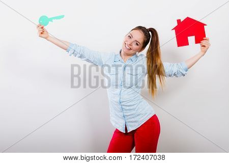 Happy young woman girl holding red paper house and key dreaming about new home house. Housing and real estate concept.