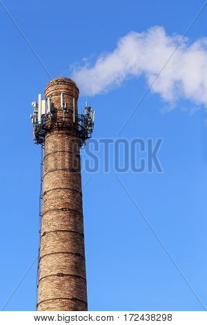 Smoke from pipe on a background of clear sky