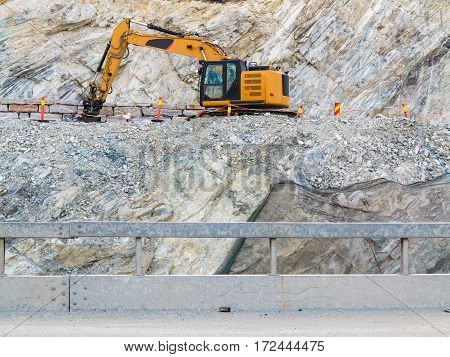 Industry. Heavy duty excavator machine digger bulldozer working on stone construction site Norway Scandinavia