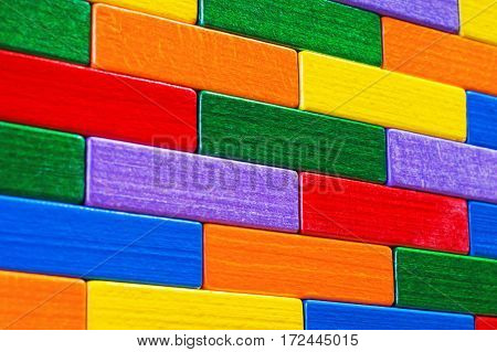 Multicolored wood background. Background with colorful shapes wooden blocks. Colorful wall toy colored wooden bricks. Multicolor wooden blocks.