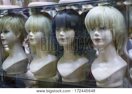 Several mannequins with wigs on display. Sale