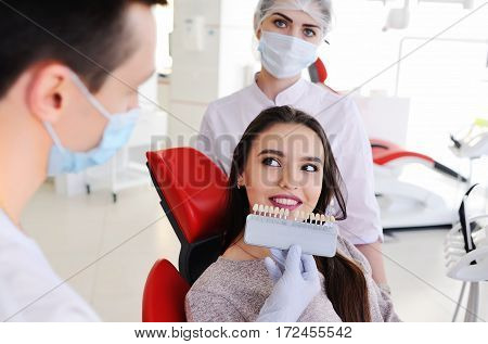 choose the color of the teeth. two dental pick the color of tooth enamel for the patient