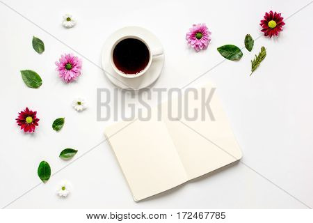 Froral flat lay with cup of coffee and craft notepaper on white background top view mockup