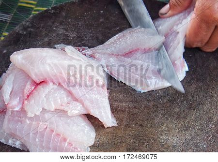 Fresh fish are being cut for cooking.