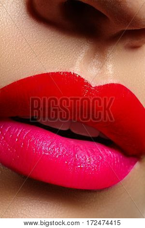 Cosmetics makeup and trends. Bright lip gloss and lipstick on lips. Closeup of beautiful female mouth with red and pink lip makeup. Beautiful part of female face. Perfect clean skin