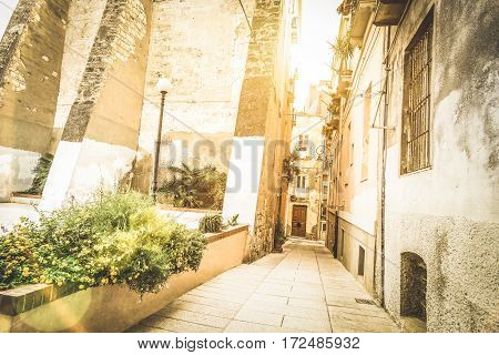 Medieval narrow street in the old city of Cagliari at sunset - World famous european city in the italian region of Sardinia - Wanderlust and travel concept on Italy destinations - Warm sunshine filter