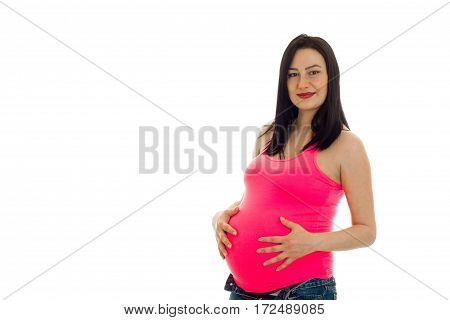 beautiful pregnant girl in a bright t-shirt keeps the hands behind the stomach isolated on white