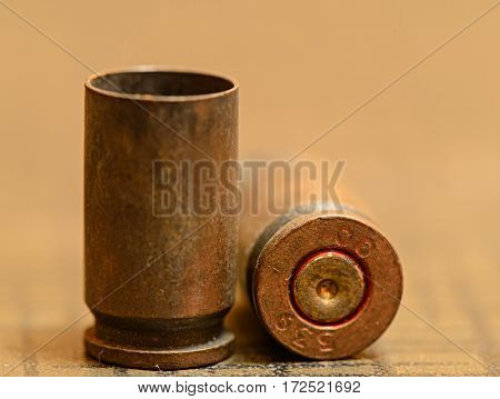 Empty 9mm bullet shell casings, on a wooden background