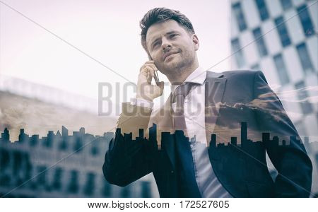 Low angle view of smart businessman talking on mobile phone against office building