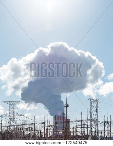 Clouds of thick smoke NPP Nuclear Power Plant in rays of bright sunlight. Vertical photo with copy space for text