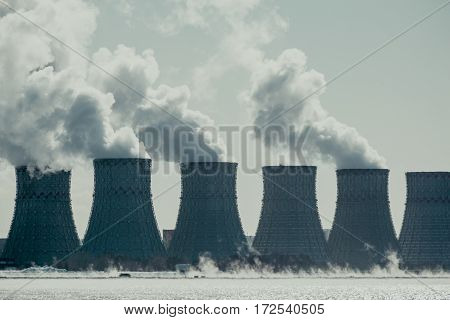 Cooling towers of NPP or Nuclear Power Plant with thick smoke. Dark toned image. Ecological disaster concept