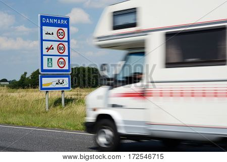 Photo with Danish border sign by the road.